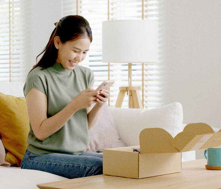 Woman opening a box with a phone inside