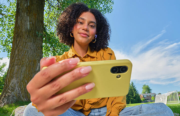 A person looking at their cell phone in a park